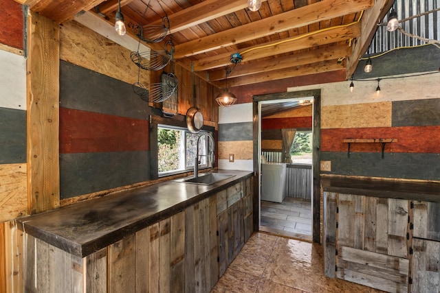 1100 Graham Rd, Cusick, WA 99119 - kitchen with stone tile flooring, wooden ceiling with exposed beams, a sink, dark countertops, and washer / dryer