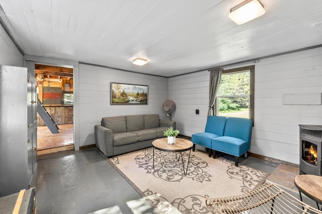 1100 Graham Rd, Cusick, WA 99119 - living area featuring concrete floors, wood walls, heating unit, and baseboards