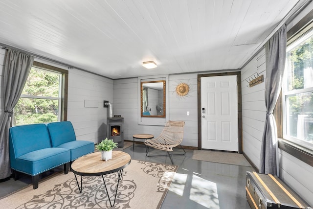 1100 Graham Rd, Cusick, WA 99119 - living area featuring a wood stove, finished concrete flooring, healthy amount of natural light, and wood walls