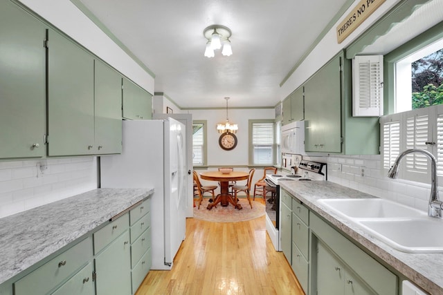 1211 W 17th Ave, Spokane, WA 99203 - kitchen featuring white appliances, a sink, green cabinets, a chandelier, and light wood-type flooring