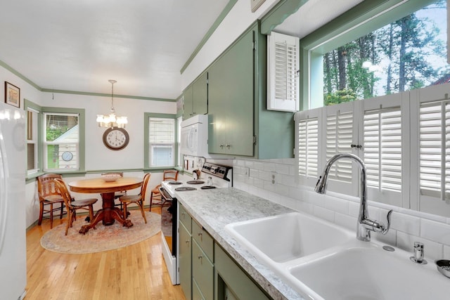 1211 W 17th Ave, Spokane, WA 99203 - kitchen with green cabinetry, white appliances, a sink, a chandelier, and light countertops