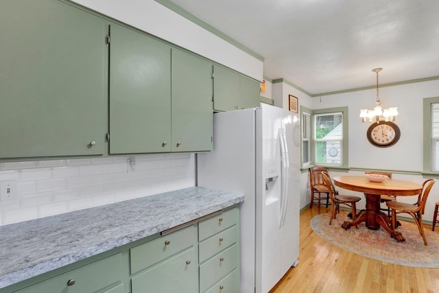 1211 W 17th Ave, Spokane, WA 99203 - kitchen with a chandelier, green cabinets, light countertops, white fridge with ice dispenser, and ornamental molding