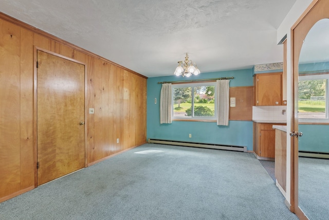 11132 S Silver Lake Rd, Medical Lake, WA 99022 - unfurnished dining area with a baseboard heating unit, light carpet, a chandelier, wood walls, and a textured ceiling