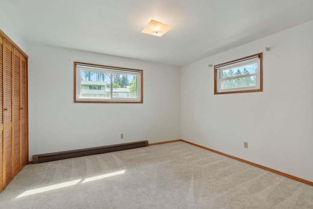 11132 S Silver Lake Rd, Medical Lake, WA 99022 - unfurnished bedroom with baseboard heating, multiple windows, a closet, and carpet floors