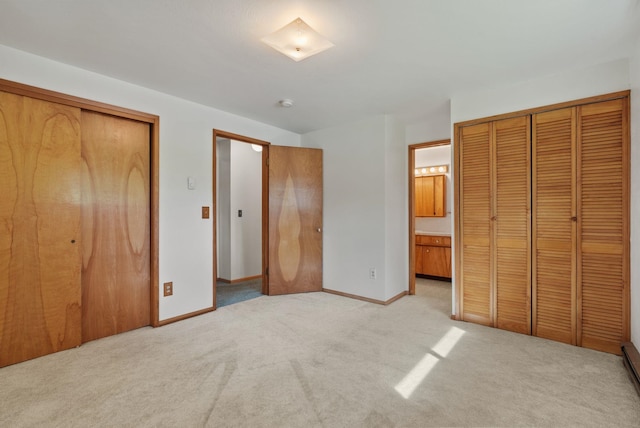 11132 S Silver Lake Rd, Medical Lake, WA 99022 - unfurnished bedroom with light colored carpet, two closets, baseboards, and ensuite bath