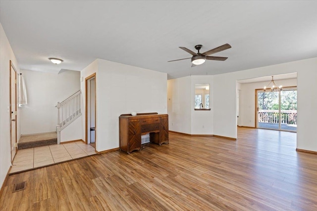 4227 E 38th Ave, Spokane, WA 99223 - unfurnished living room with light wood-style floors, a ceiling fan, a chandelier, baseboards, and stairway