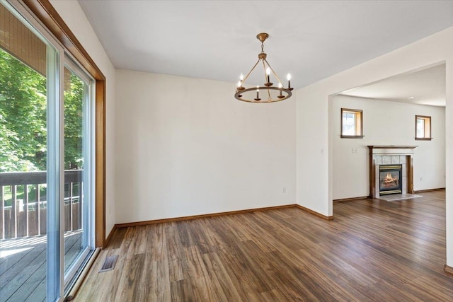 4227 E 38th Ave, Spokane, WA 99223 - spare room with wood finished floors, a chandelier, baseboards, and a tiled fireplace