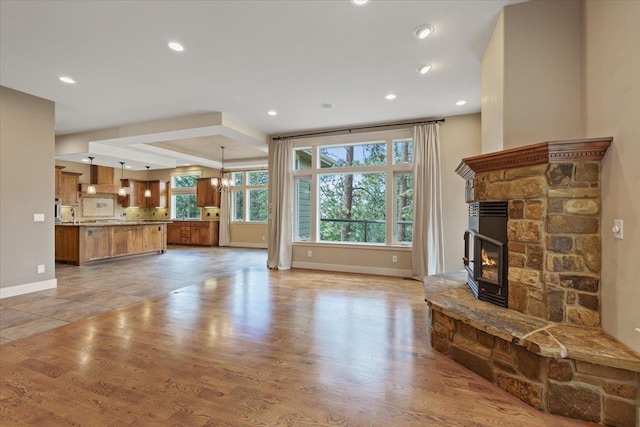 223 N Lindeblad Ln, Liberty Lake, WA 99019 - unfurnished living room featuring baseboards, a stone fireplace, recessed lighting, and light wood-style flooring