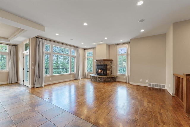 223 N Lindeblad Ln, Liberty Lake, WA 99019 - unfurnished living room featuring healthy amount of natural light, baseboards, a stone fireplace, recessed lighting, and tile patterned flooring