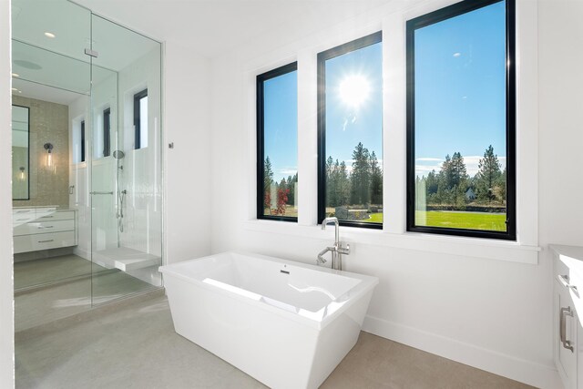 13858 N Boulder Park Ln, Spokane, WA 99208 - full bathroom featuring vanity, a soaking tub, a stall shower, and baseboards
