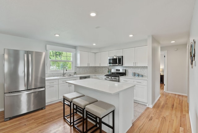 814 N Mamer Rd, Spokane Valley, WA 99216 - kitchen featuring appliances with stainless steel finishes, a sink, a breakfast bar area, white cabinets, and light countertops