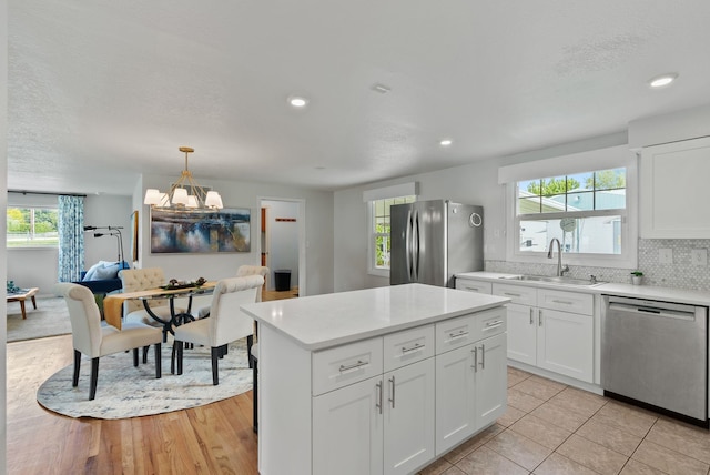 814 N Mamer Rd, Spokane Valley, WA 99216 - kitchen featuring appliances with stainless steel finishes, a sink, light countertops, a chandelier, and white cabinetry