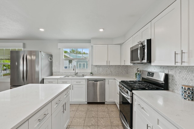 814 N Mamer Rd, Spokane Valley, WA 99216 - kitchen featuring appliances with stainless steel finishes, a sink, light tile patterned floors, backsplash, and light countertops