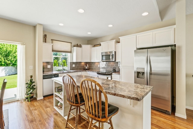 13202 N Addison St, Spokane, WA 99208 - kitchen featuring appliances with stainless steel finishes, tasteful backsplash, light wood-style flooring, white cabinetry, and recessed lighting