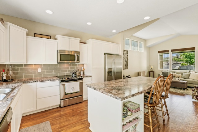 13202 N Addison St, Spokane, WA 99208 - kitchen featuring stainless steel appliances, a breakfast bar, a center island, light wood-style floors, and open floor plan