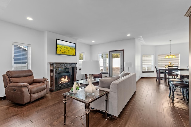 3260 W Magistrate Loop, Hayden, ID 83835 - living room with a glass covered fireplace, dark wood-style flooring, recessed lighting, a chandelier, and baseboards