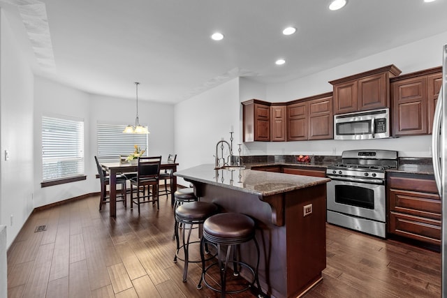3260 W Magistrate Loop, Hayden, ID 83835 - kitchen with stainless steel appliances, a sink, a breakfast bar, a peninsula, and recessed lighting