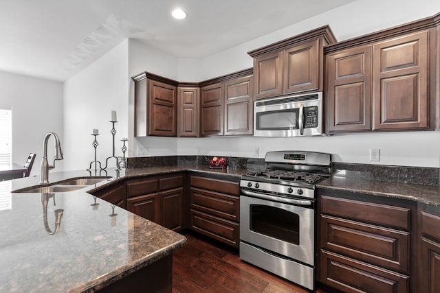 3260 W Magistrate Loop, Hayden, ID 83835 - kitchen with appliances with stainless steel finishes, a sink, dark wood finished floors, dark stone counters, and dark brown cabinetry