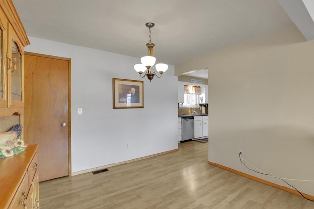 11307 E 8th Ave, Spokane Valley, WA 99206 - unfurnished dining area featuring light wood finished floors, a chandelier, a sink, and baseboards
