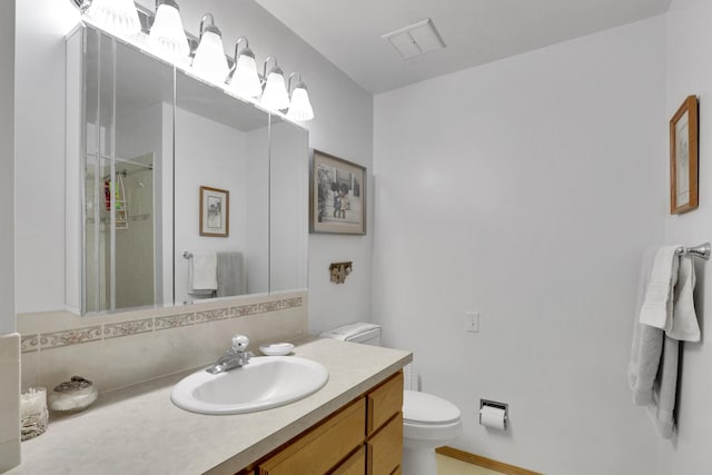 11307 E 8th Ave, Spokane Valley, WA 99206 - bathroom featuring toilet, vanity, a shower with door, and tasteful backsplash
