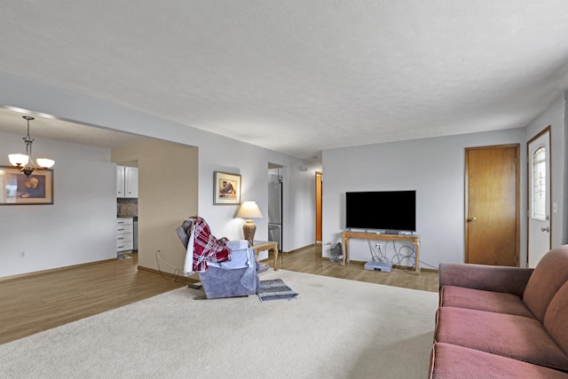 11307 E 8th Ave, Spokane Valley, WA 99206 - living room featuring light wood-type flooring, a chandelier, and baseboards