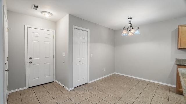 12218 W 10th Ave, Airway Heights, WA 99001 - unfurnished dining area with light tile patterned floors, a chandelier, and baseboards
