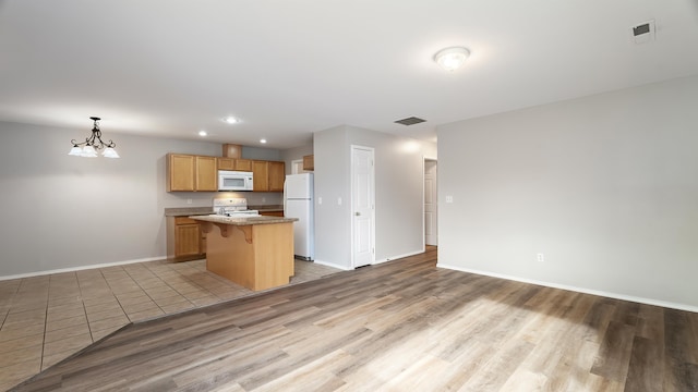12218 W 10th Ave, Airway Heights, WA 99001 - kitchen featuring white appliances, light wood finished floors, baseboards, a breakfast bar area, and recessed lighting
