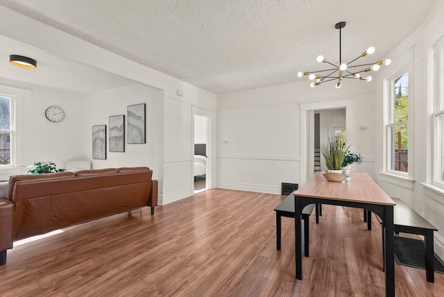 2018 E 6th Ave, Spokane, WA 99202 - dining area with a chandelier, wood finished floors, a textured ceiling, and baseboards