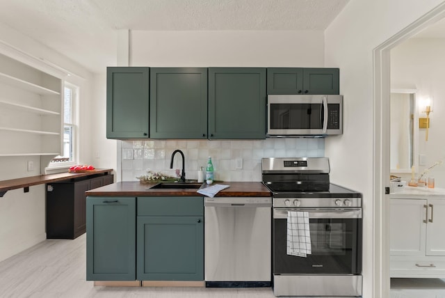 2018 E 6th Ave, Spokane, WA 99202 - kitchen with appliances with stainless steel finishes, green cabinets, and a sink