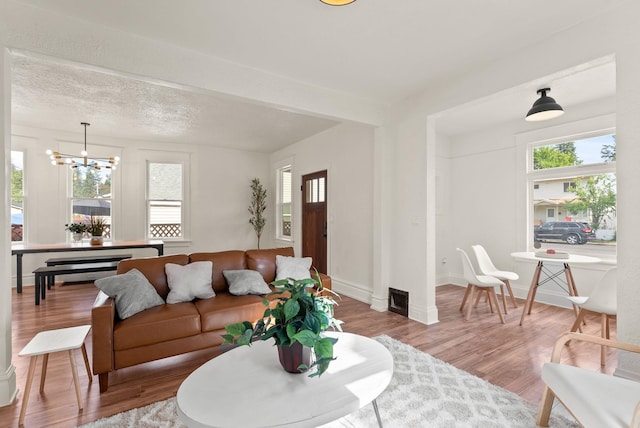 2018 E 6th Ave, Spokane, WA 99202 - living area featuring a chandelier, wood finished floors, and baseboards