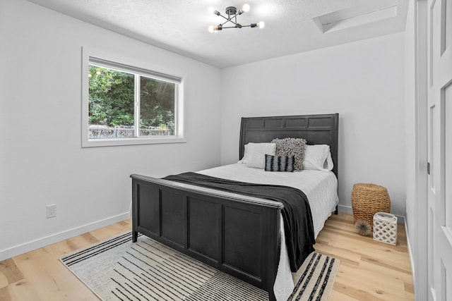 12916 N Newman St, Newman Lake, WA 99025 - bedroom featuring attic access, light wood-style flooring, baseboards, and a textured ceiling
