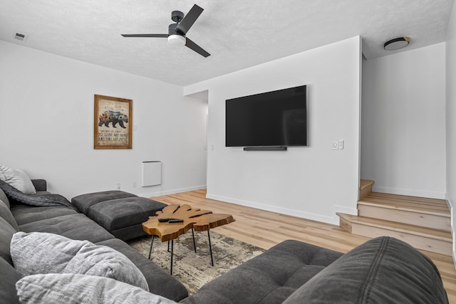 12916 N Newman St, Newman Lake, WA 99025 - living room with a textured ceiling, light wood-style flooring, ceiling fan, baseboards, and stairs