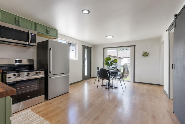 1509 N Lee St, Spokane, WA 99207 - kitchen featuring green cabinetry, appliances with stainless steel finishes, a barn door, light wood-style flooring, and recessed lighting