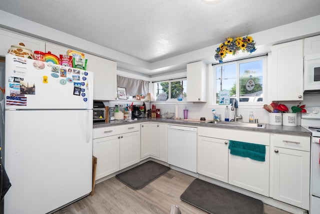 1503 E Dalton Ave, Spokane, WA 99207 - kitchen with white appliances, light wood-style floors, a sink, and white cabinets