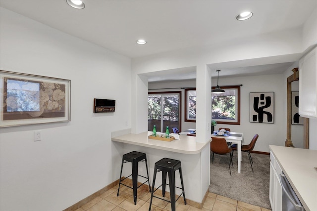 1002 W 7th Ave Unit 301, Spokane, WA 99204 - kitchen with light countertops, dishwasher, a breakfast bar, white cabinets, and recessed lighting