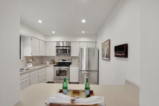 1002 W 7th Ave Unit 301, Spokane, WA 99204 - kitchen with appliances with stainless steel finishes, tasteful backsplash, white cabinets, recessed lighting, and light countertops