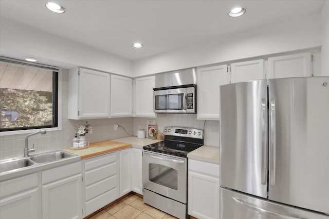 1002 W 7th Ave Unit 301, Spokane, WA 99204 - kitchen with appliances with stainless steel finishes, a sink, decorative backsplash, white cabinets, and light countertops