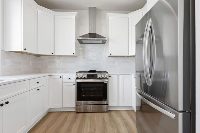 1817 N Arties Rd, Spokane Valley, WA 99016 - kitchen featuring appliances with stainless steel finishes, wall chimney range hood, light countertops, light wood-style floors, and white cabinetry