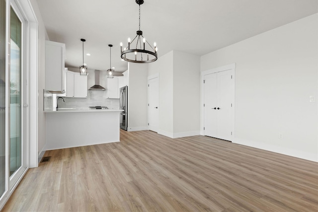 1817 N Arties Rd, Spokane Valley, WA 99016 - kitchen with wall chimney range hood, stainless steel fridge, light countertops, a chandelier, and open floor plan