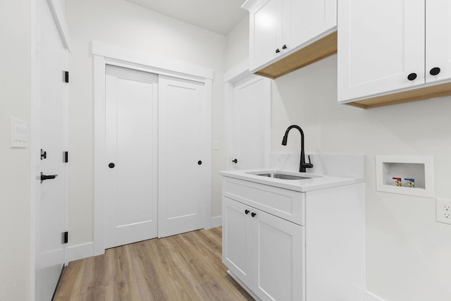 1817 N Arties Rd, Spokane Valley, WA 99016 - laundry area with hookup for a washing machine, light wood-style flooring, cabinet space, and baseboards