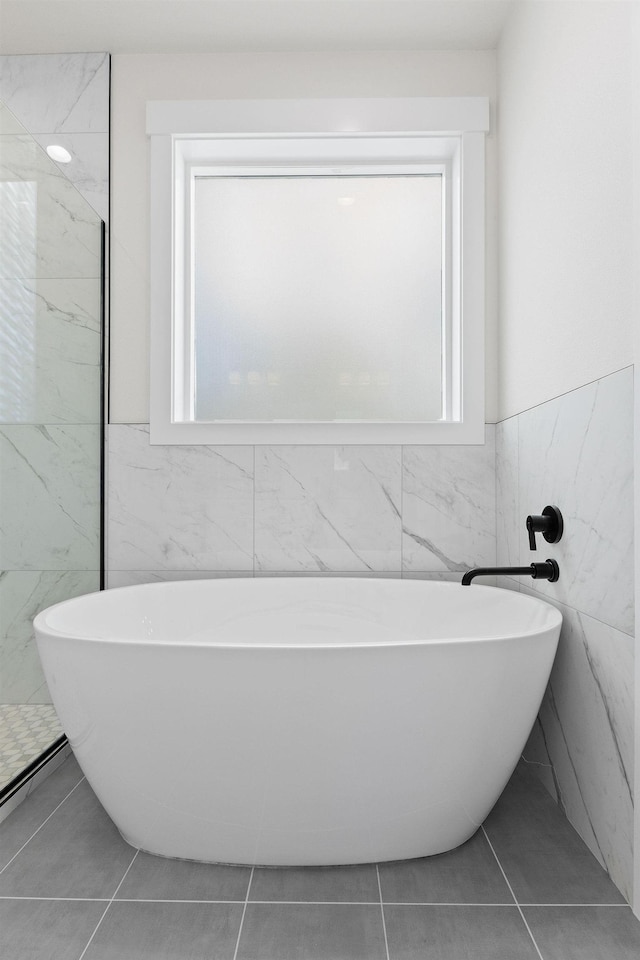 1817 N Arties Rd, Spokane Valley, WA 99016 - bathroom with tile walls, a freestanding bath, tile patterned floors, and a wainscoted wall