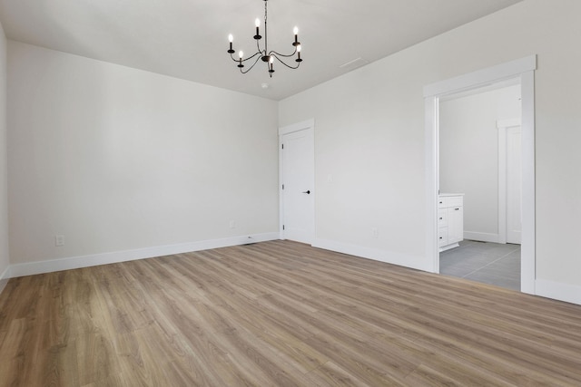 1817 N Arties Rd, Spokane Valley, WA 99016 - unfurnished room featuring a chandelier, wood finished floors, and baseboards