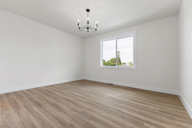 1817 N Arties Rd, Spokane Valley, WA 99016 - spare room featuring a chandelier, baseboards, and light wood-style flooring