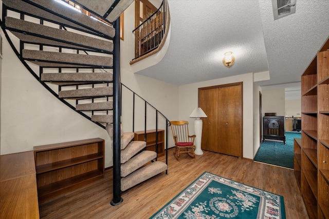 16905 N Mockingbird Ct, Nine Mile Falls, WA 99026 - entrance foyer featuring stairway, wood finished floors, a textured ceiling, and baseboards