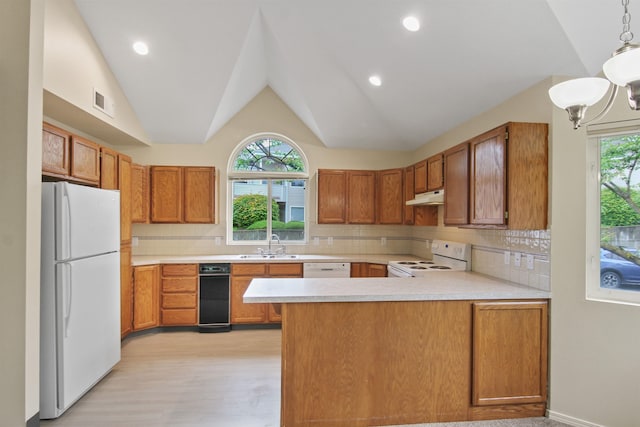 221 E Rockwood Blvd Unit 12, Spokane, WA 99202 - kitchen with white appliances, under cabinet range hood, a peninsula, light countertops, and vaulted ceiling