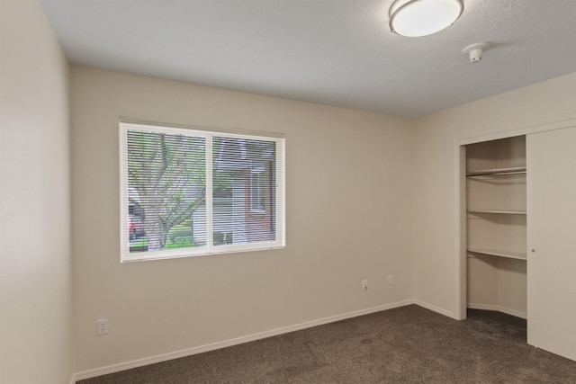 221 E Rockwood Blvd Unit 12, Spokane, WA 99202 - unfurnished bedroom featuring dark carpet, baseboards, and a closet