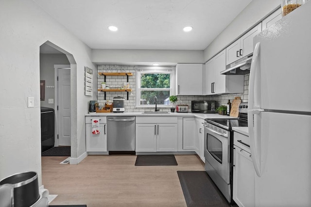 811 E Dalke Ave, Spokane, WA 99208 - kitchen featuring appliances with stainless steel finishes, under cabinet range hood, a sink, decorative backsplash, and white cabinets