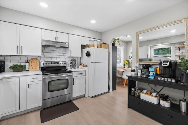 811 E Dalke Ave, Spokane, WA 99208 - kitchen with stainless steel electric stove, under cabinet range hood, freestanding refrigerator, light countertops, and recessed lighting