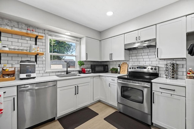 811 E Dalke Ave, Spokane, WA 99208 - kitchen with stainless steel appliances, under cabinet range hood, a sink, white cabinetry, and recessed lighting