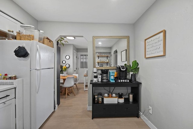 811 E Dalke Ave, Spokane, WA 99208 - kitchen with freestanding refrigerator, light wood-type flooring, arched walkways, and baseboards